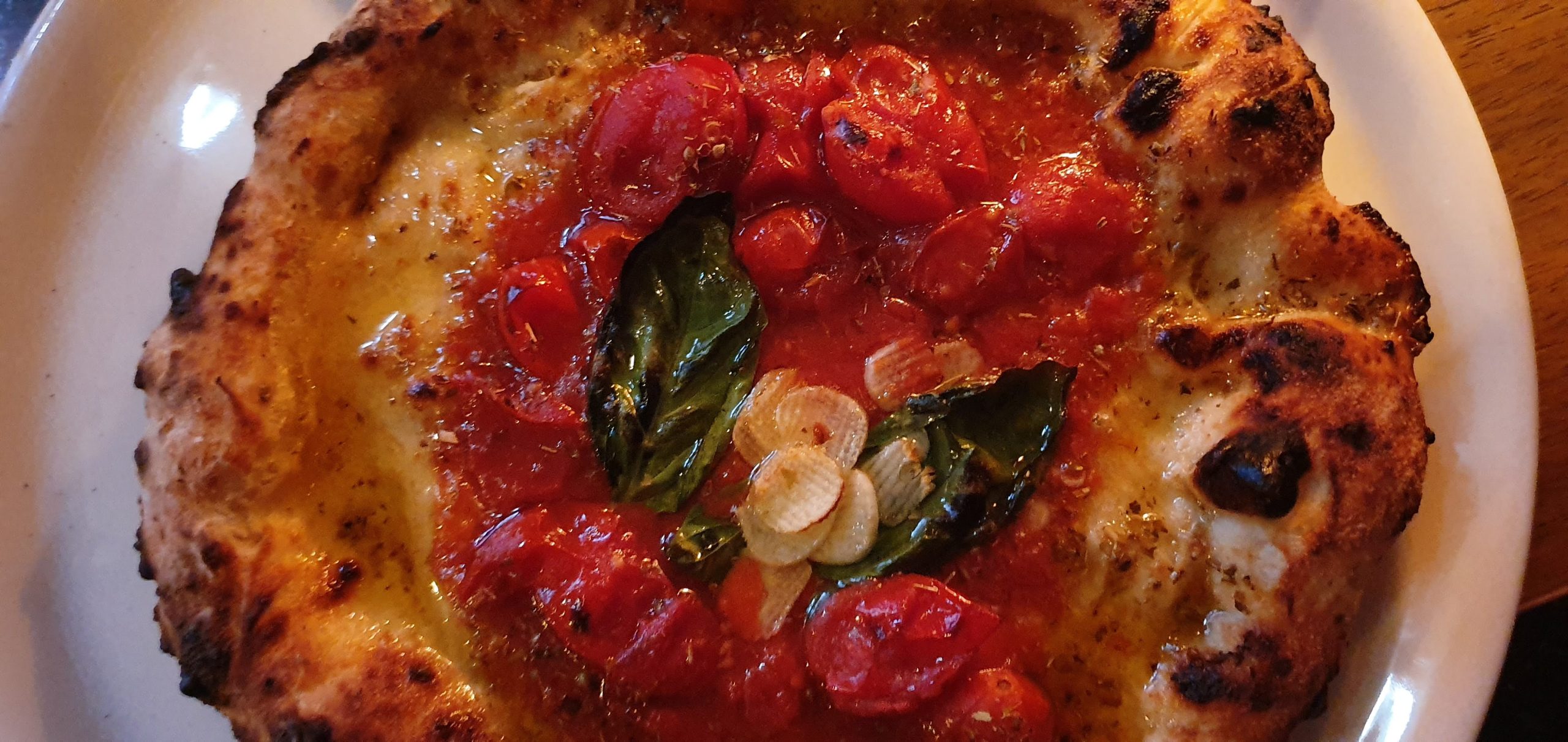 Nakameguro 39 scaled A pizza topped with tomatoes, garlic and basil at Seirinkan
