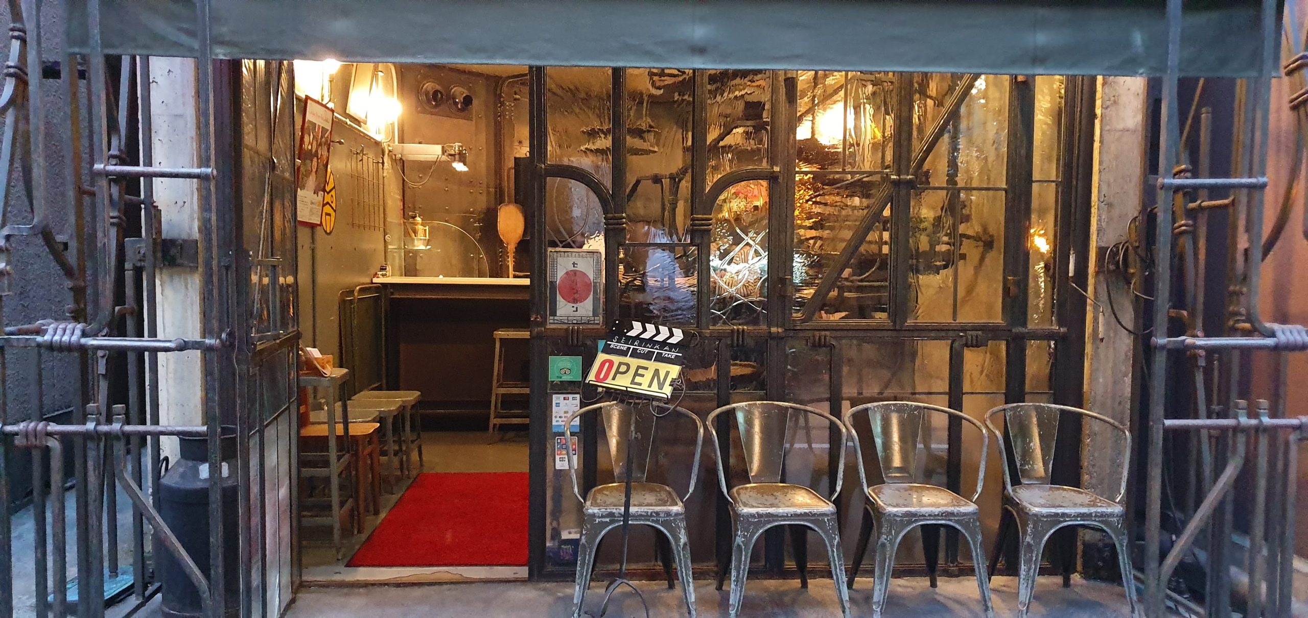 Nakameguro 44 scaled The metal-framed entrance and row of chairs outside Seirinkan in 2019