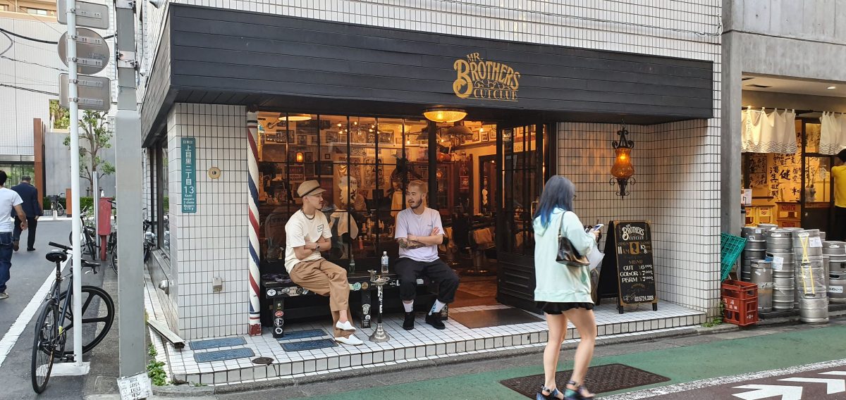 Nakameguro 7 A shopfront with people sitting outside on a street in Nakameguro