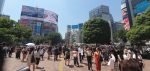 Pedestrians beside Shibuya Scramble Crossing on a sunny day