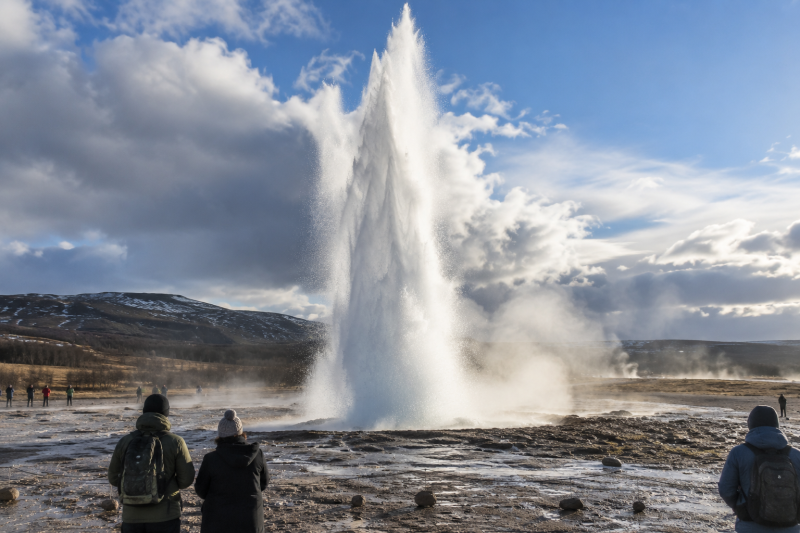 Strokkur Geyser Erupting in Iceland Strokkur geyser erupting as visitors watch from a safe distance in Iceland