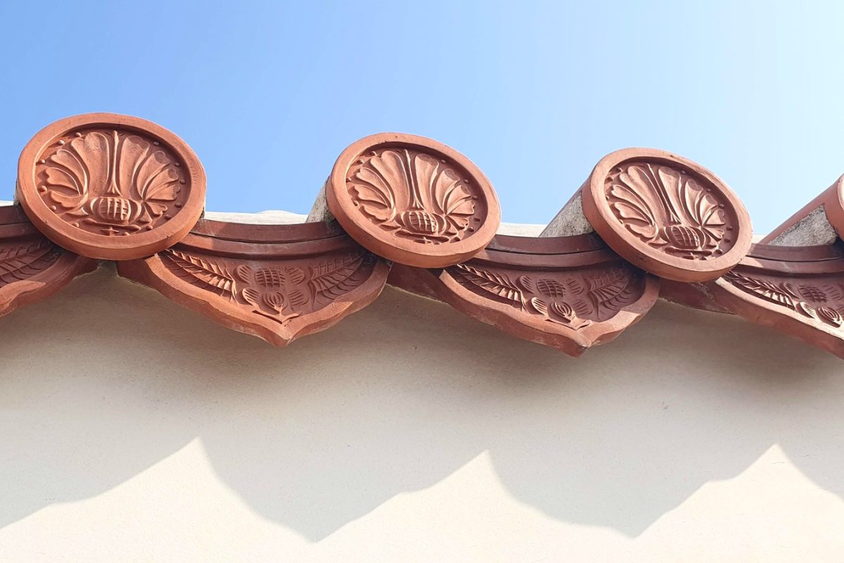 Terracotta roof tiles in Okinawa Three decorative terracotta roof tiles above a pale wall in Okinawa.