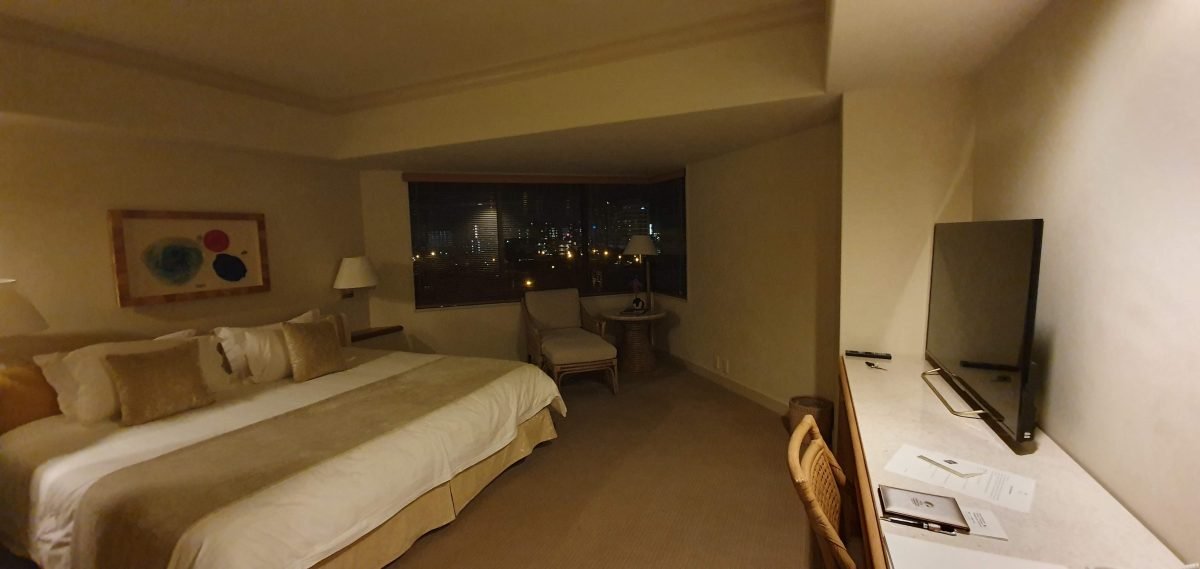 Bed, seating area and desk in our room at The Naha Terrace