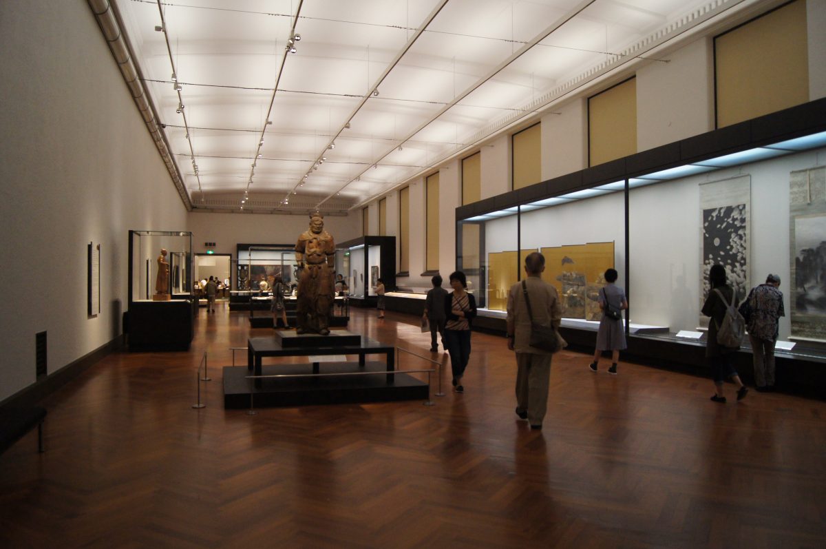 Tokyo National Museum 2015 124 Spacious museum gallery interior with a large central statue, traditional Japanese screens, and scrolls on display, at the Tokyo National Museum.