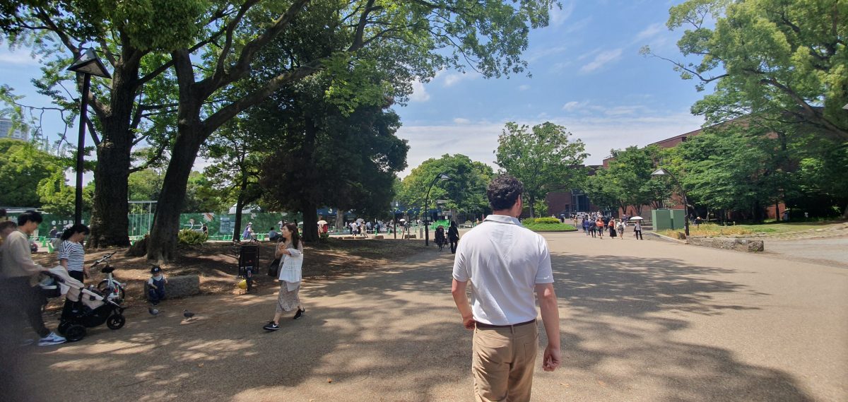 Gary walking through the tree-lined plaza in Ueno Park, Tokyo