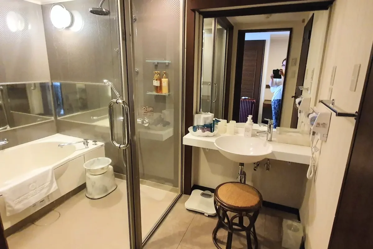 Bathroom with a bathtub, glass shower enclosure and washbasin at Grandvrio Resort Ishigakijima