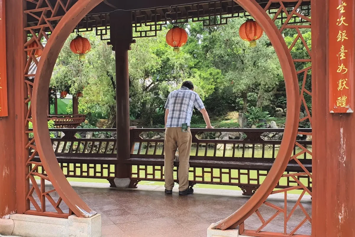 okinawa gary at fukushu en garden 11458 Gary looking over the pond through a circular pavilion doorway at Fukushu-en Garden