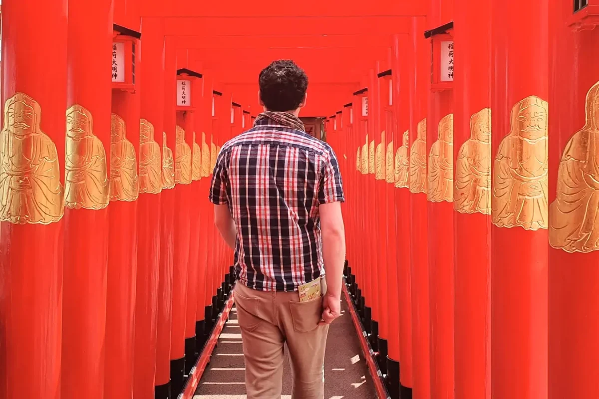 Gary standing between red gates at the temple in Shuri