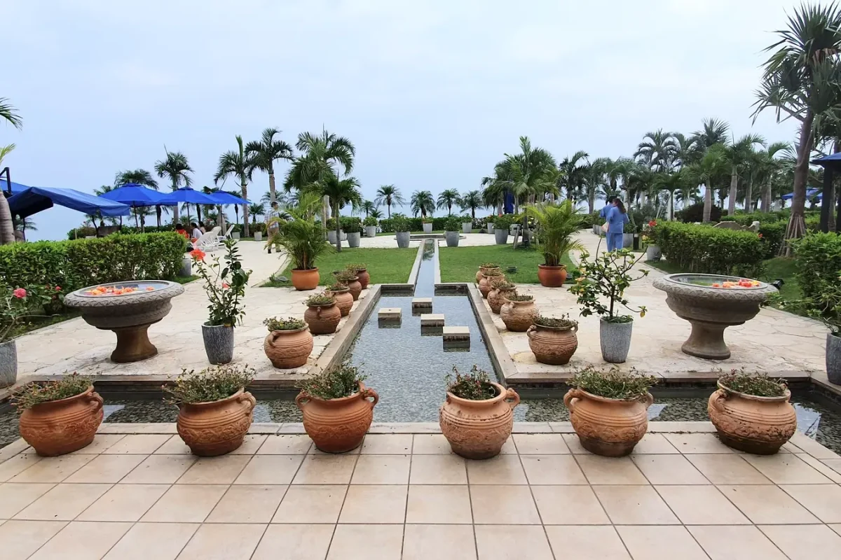 Landscaped terrace with potted plants, palms and a central water channel at Grandvrio Resort Ishigakijima