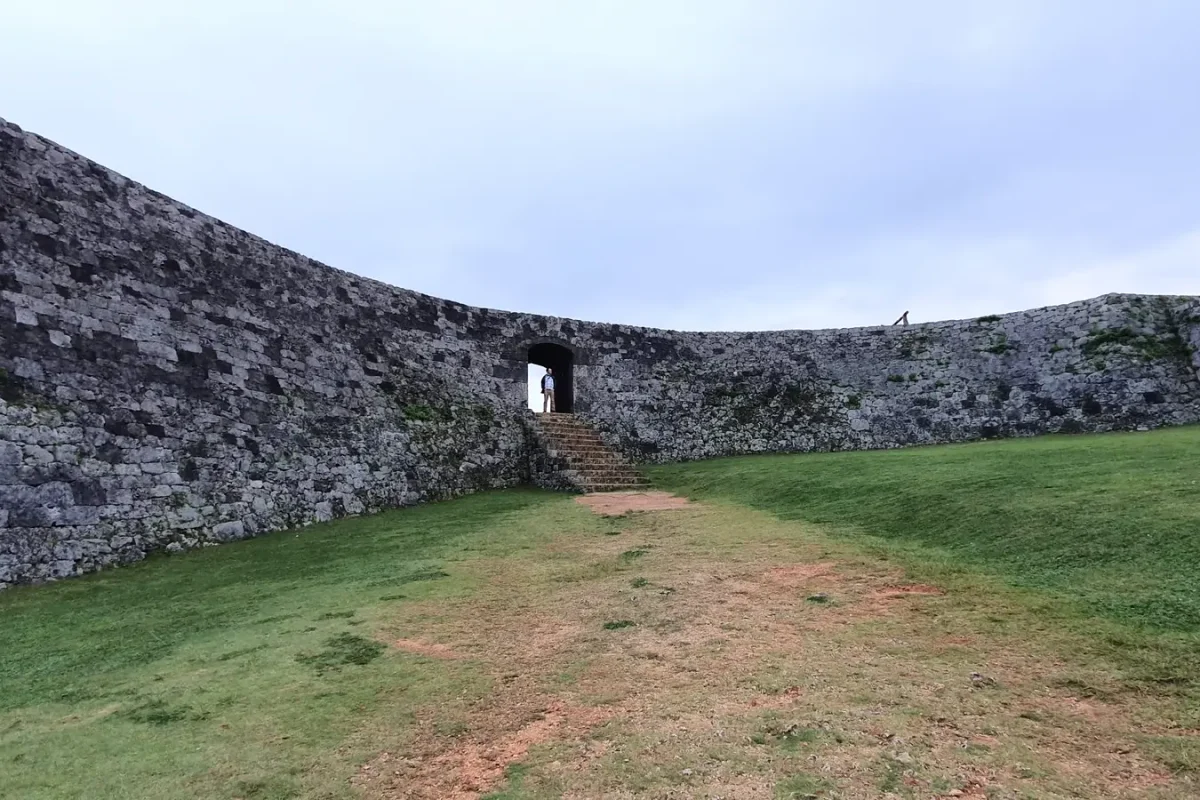 Grassy courtyard enclosed by curved stone walls at Zakimi Castle ruins