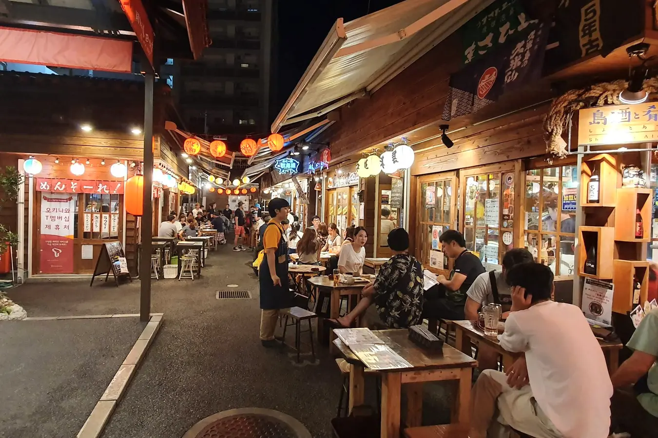 Lantern-lit restaurants inside Kokusai Street Food Village at night