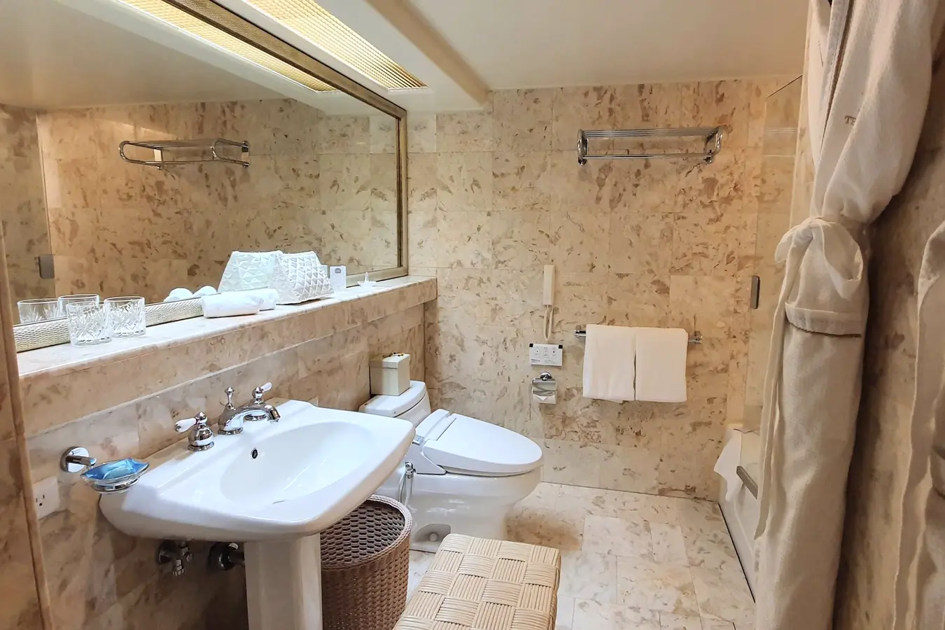 Marble bathroom with robes at The Naha Terrace in Okinawa