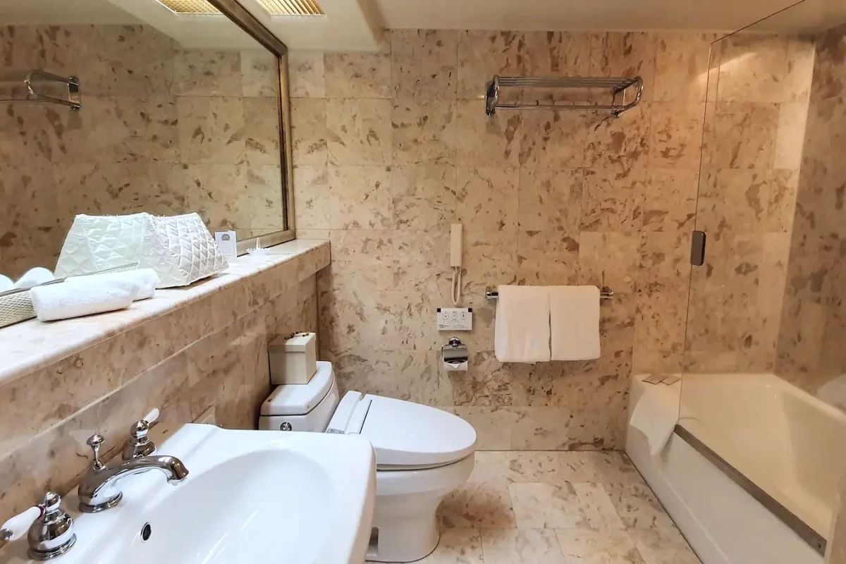 Marble bathroom with basin and bathtub at The Naha Terrace