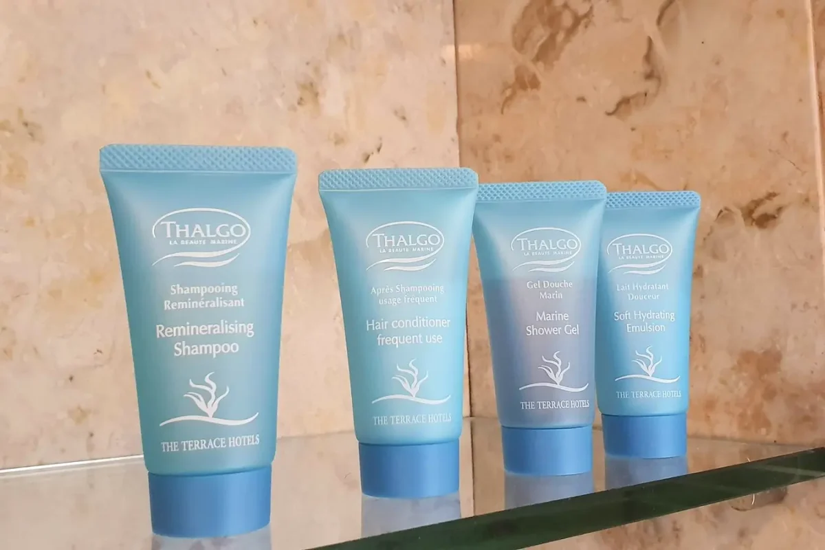 Toiletries arranged on a glass bathroom shelf at The Naha Terrace