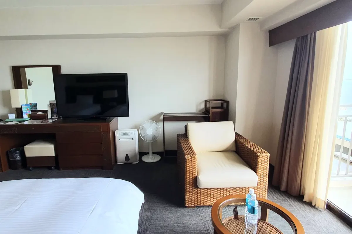 Television, desk and seating area beside the balcony door in our Grandvrio Resort room