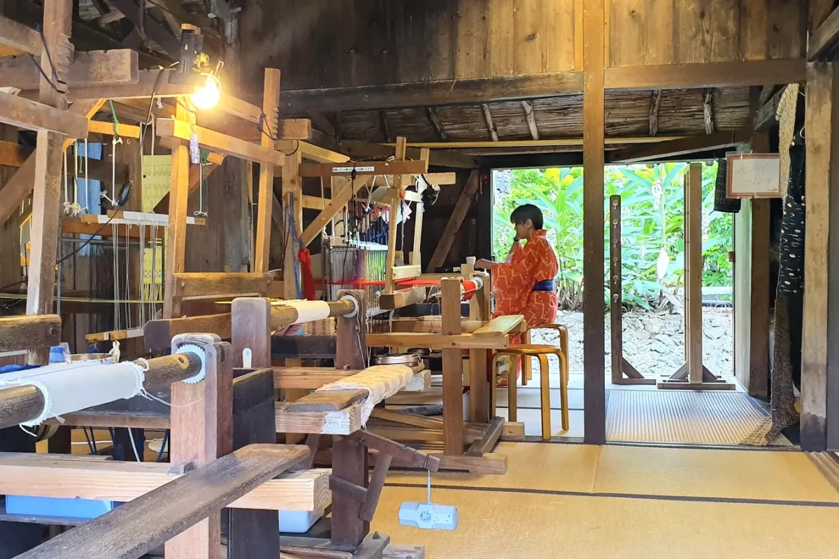 Wooden looms inside a traditional weaving room at Ryukyu Mura