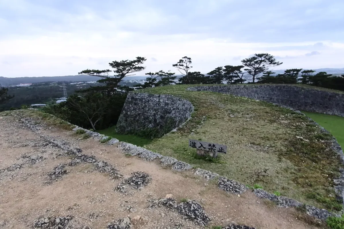 Curving stone walls and the surrounding landscape at Zakimi Castle