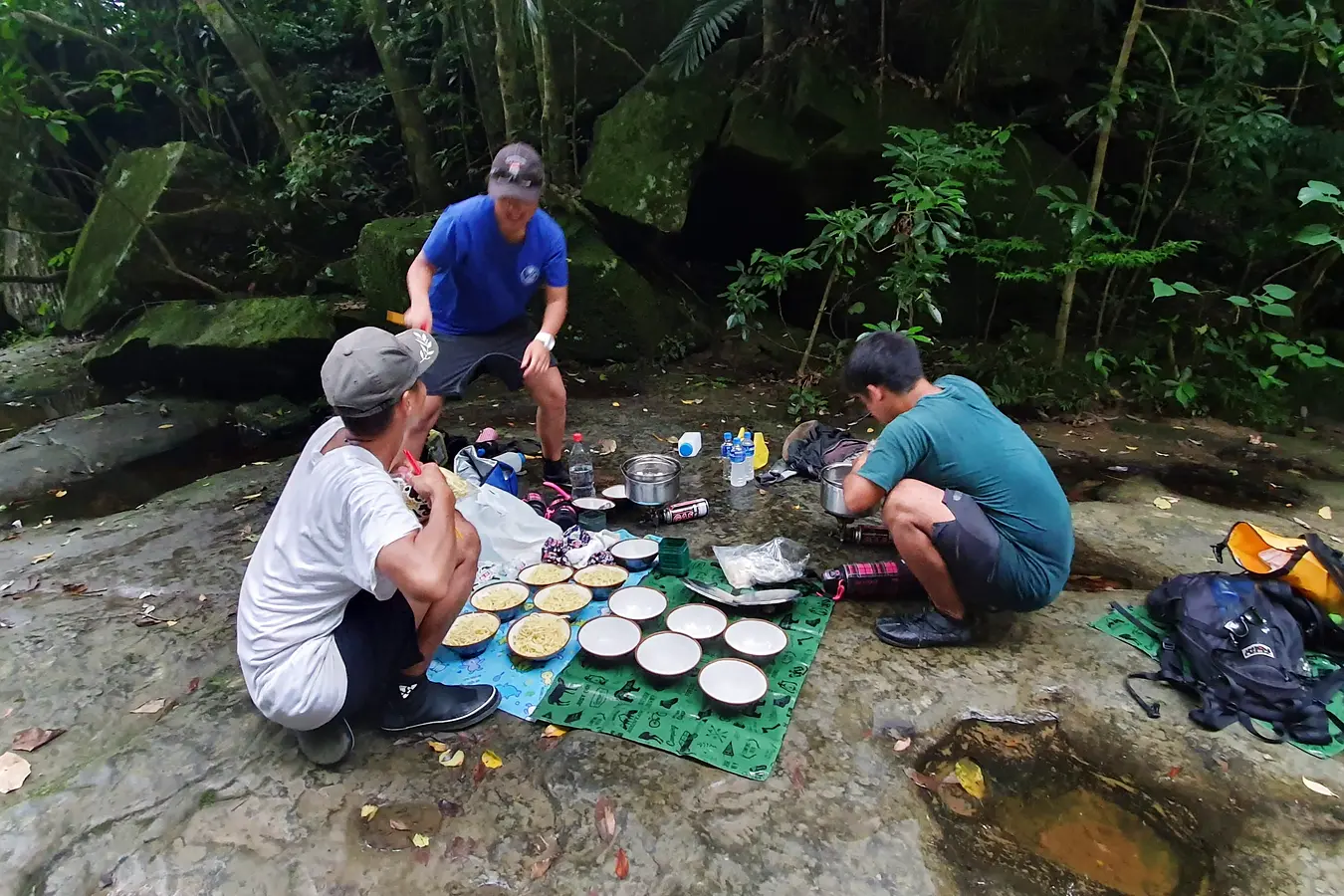 Our guides preparing an outdoor noodle lunch beside the stream at Pinaisara Falls