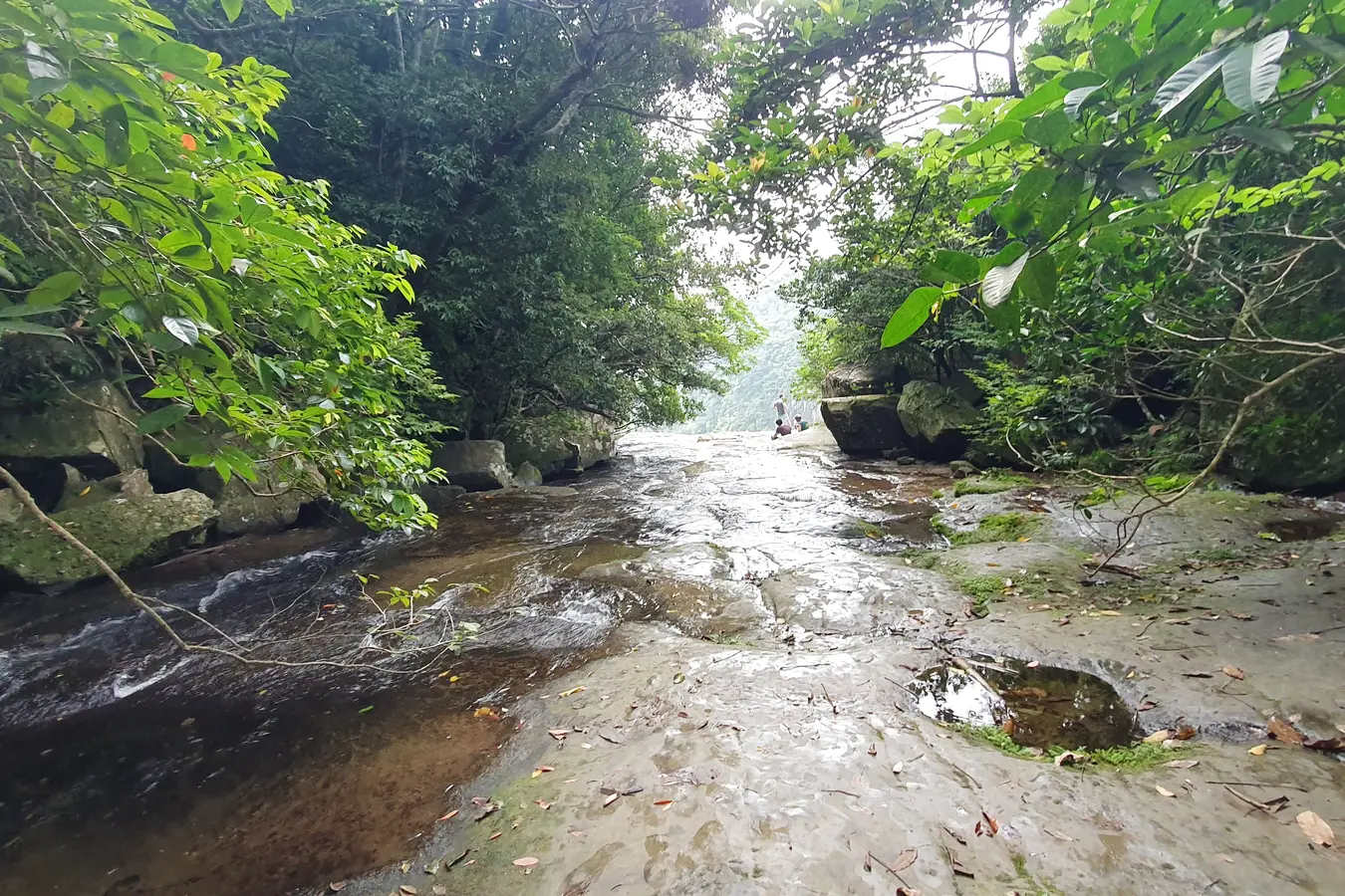 Water flowing over an uneven rocky riverbed above Pinaisara Falls